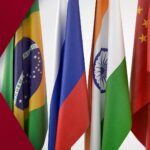 South African foreign ministry spokesperson addressing media against national flag backdrop, confirming unchanged BRICS policy under new government