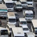 Aerial view of a bustling Egyptian port showing colorful cargo containers neatly stacked and large cranes loading and unloading ships under a clear sky