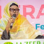 Warm golden hour light bathes rolling green hills and a solitary tree standing on the crest