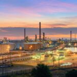 Vibrant abstract geometric composition featuring overlapping triangles and circles in bright red, teal, yellow and navy on white background