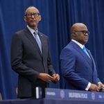 Bright, glass-walled conference room with a long white table and ten black office chairs; the downtown skyline is visible through the panoramic windows.