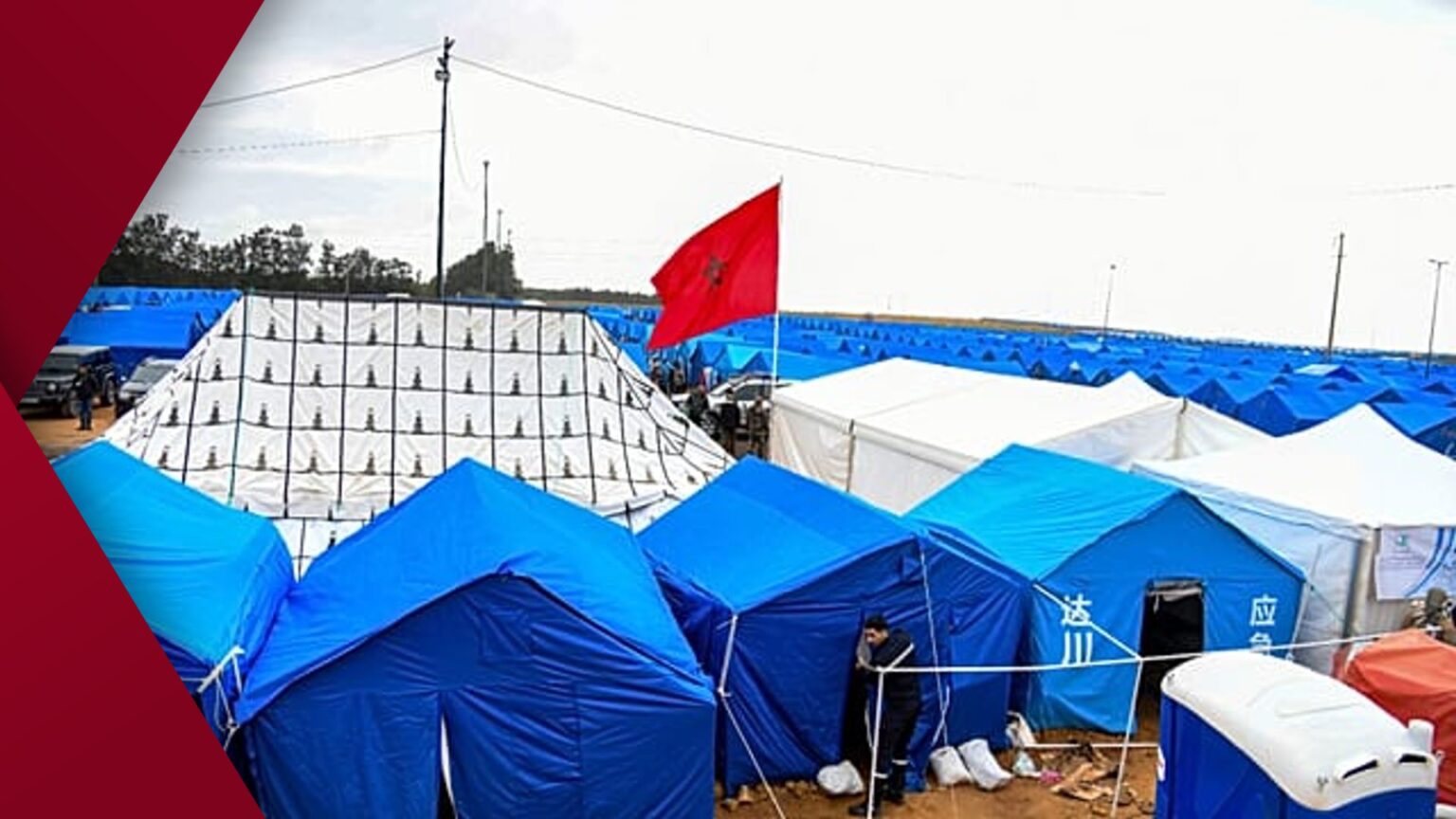 Modern glass high-rise building featuring a precise geometric grid pattern on its facade reflecting blue sky and clouds