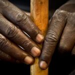 Modern high-rise office building featuring a fully reflective glass exterior that mirrors the surrounding cityscape and sky