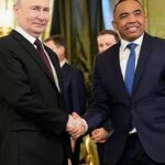 Sleek modern glass skyscraper with a perfect reflection of blue sky and white clouds on its mirrored façade