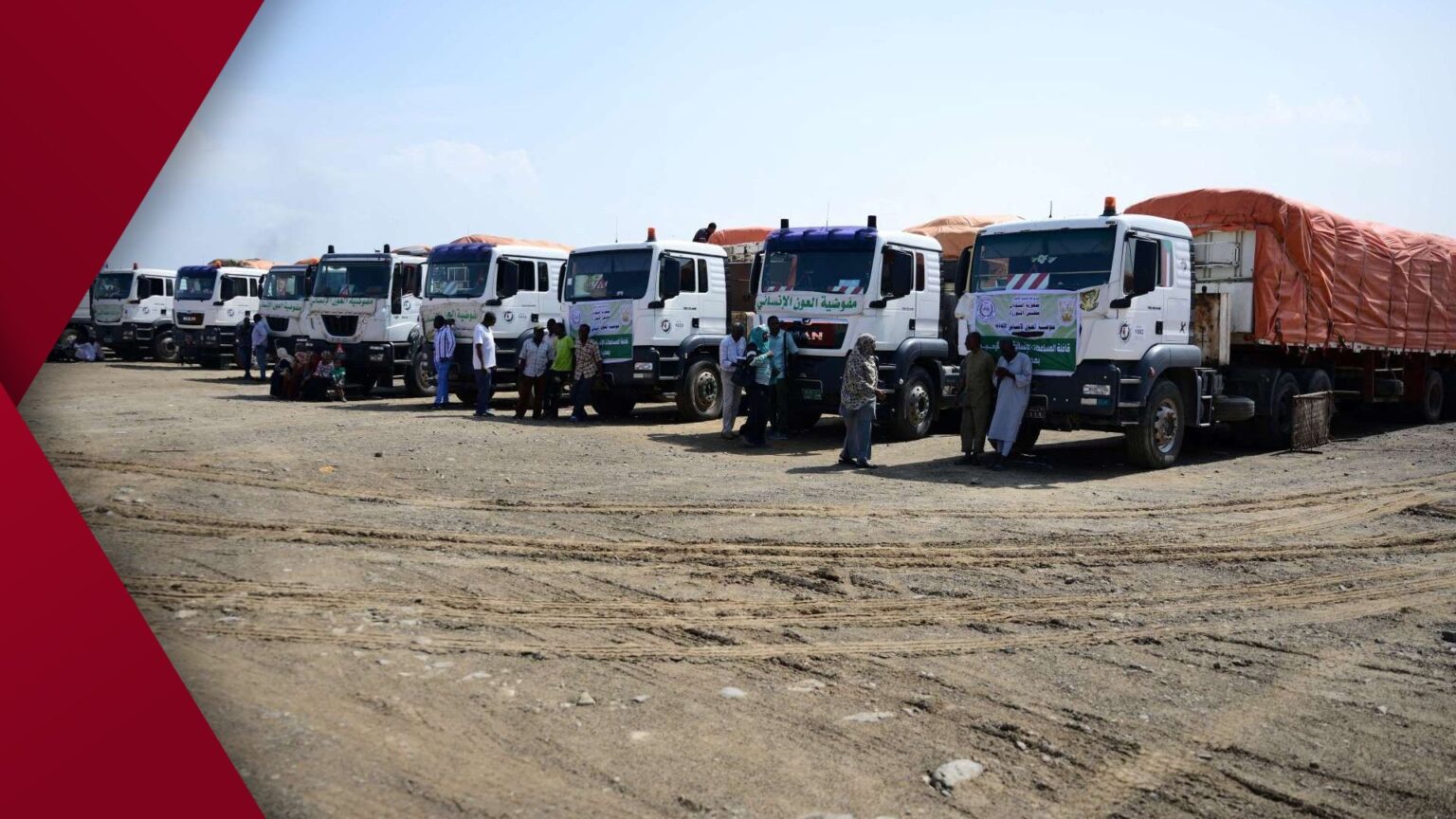 Long queue of Sudanese families with children and jerrycans waiting for emergency food and water distribution in a dusty North Darfur camp