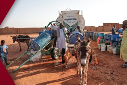 Multiple AP journalists focus intently on computer screens and printed pages while editing breaking news in a busy open-plan newsroom