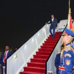 Golden Retriever mid-stride running on a bright green grassy field in a sunny park