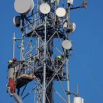 Abstract digital texture featuring flowing teal and gold light streaks on a dark background