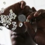 Adorable golden retriever puppy lying down and gently holding a colorful chew toy in its mouth