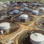 Abstract swirling marble pattern in rich teal and shimmering gold veins