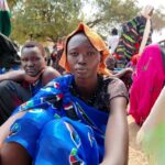 Side view of a sleek ergonomic black office chair with a high mesh backrest, adjustable armrests, and a five-star wheeled base, isolated on a pure white background