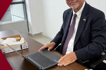 Five-story vermilion pagoda of a Zen temple perfectly reflected in a calm pond surrounded by fiery red and gold autumn foliage